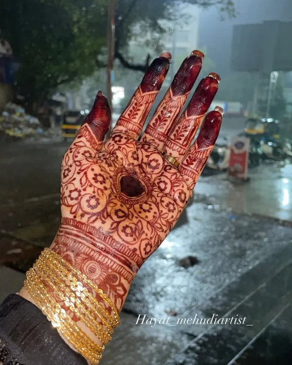 This is the kind of deep, rich stain that is my `ishq`. I achieve this color using my own handmade organic henna cones, which are always mixed fresh with high-quality ingredients. Notice the intricate floral patterns and the beautiful, dark heart at the center of the palm.
