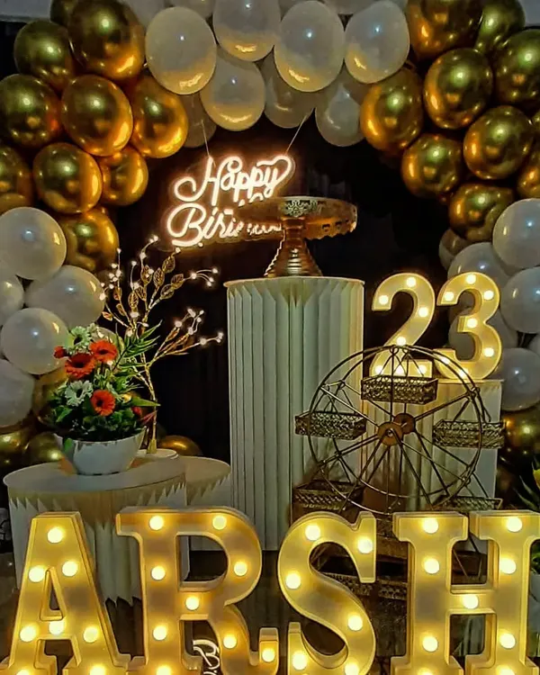 This is what a milestone birthday celebration looks like. We combined a classic gold and white balloon arch with a custom neon sign and personalized light-up letters for "ARSH" to create a stunning photo corner for the 23rd birthday party.