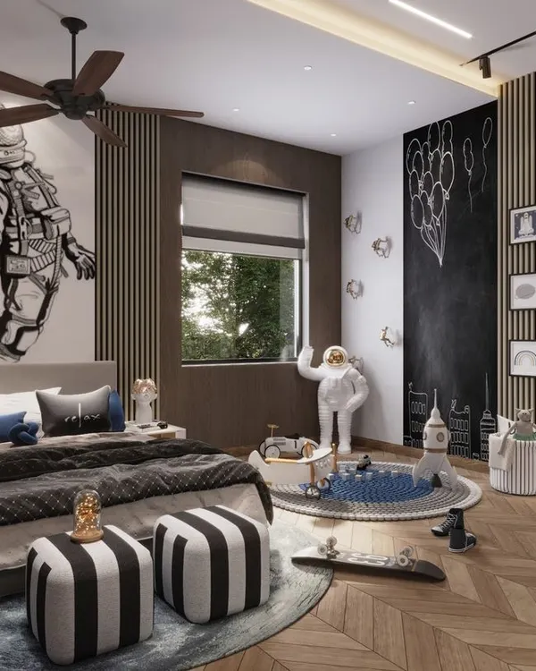 This space-themed bedroom is designed to inspire adventure. The large astronaut mural, chalkboard wall, and gallery of themed art create a dynamic and interactive environment for a young explorer.