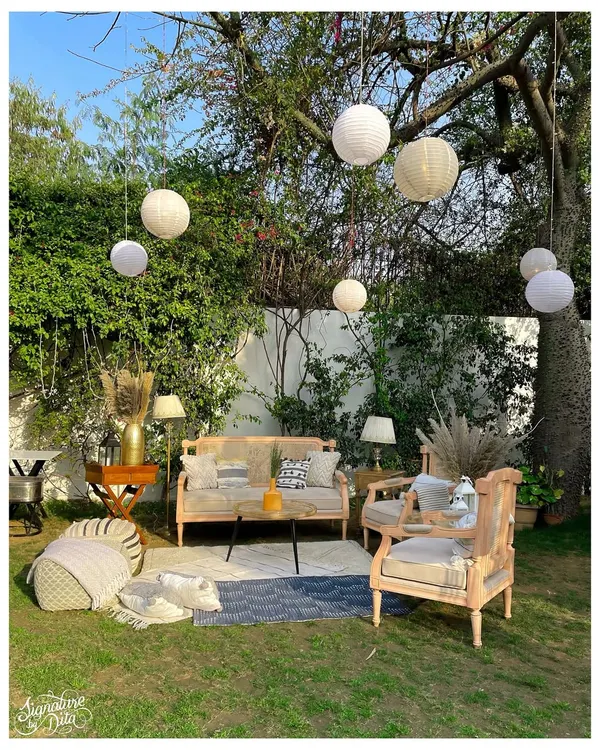 I create comfortable and stylish networking spaces, like this boho-chic outdoor lounge. The blend of natural wood furniture, soft textiles, and ambient paper lanterns provides a relaxed yet elegant setting for guests to connect.