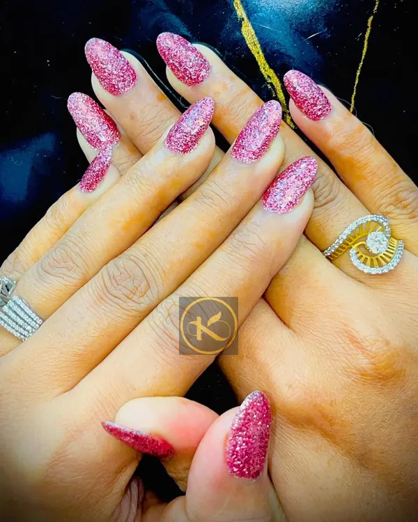 You can never go wrong with a bit of sparkle. This is a full set of almond-shaped nail extensions with a vibrant pink glitter gel polish. It is a perfect look for parties, weddings, or any time you want to feel extra glamorous.