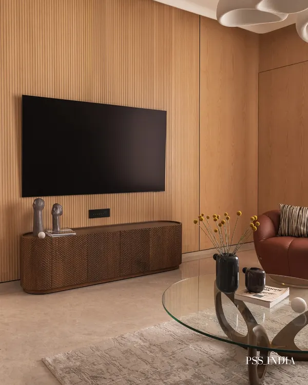 Soft tones and sculptural forms create effortless warmth in this living room. I brought together fluted wood panels, cozy textures, and organic curves to design a space that feels calm, modern, and deeply lived-in.