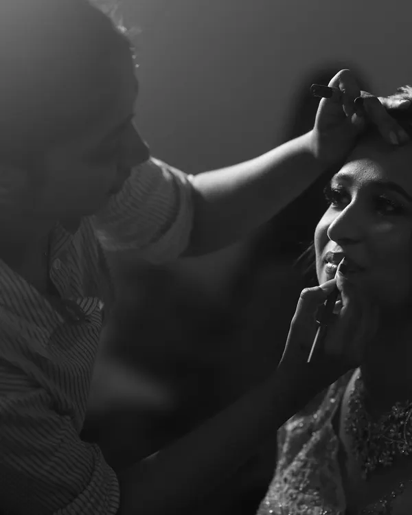 A quiet moment of focus. This black and white shot captures me applying lipstick, a crucial final step in creating the perfect bridal look.