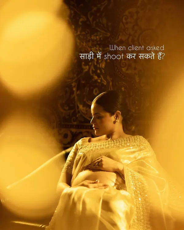 "When client asked, 'साड़ी में shoot कर सकते हैं?'" Our answer is always yes. This image, with its warm golden light and rich tapestry background, shows how beautifully a saree can be incorporated into a maternity shoot, celebrating both culture and motherhood.