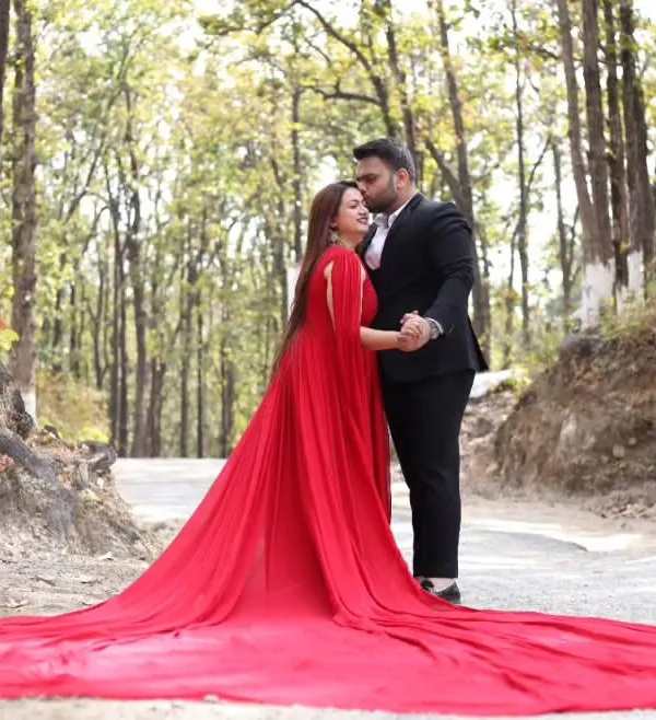 This is the ultimate showstopper gown for a truly magical maternity shoot. The dramatic red trail flows beautifully, creating a stunning contrast against natural backdrops like this forest setting. It's an adjustable infinity gown, ensuring a perfect fit.