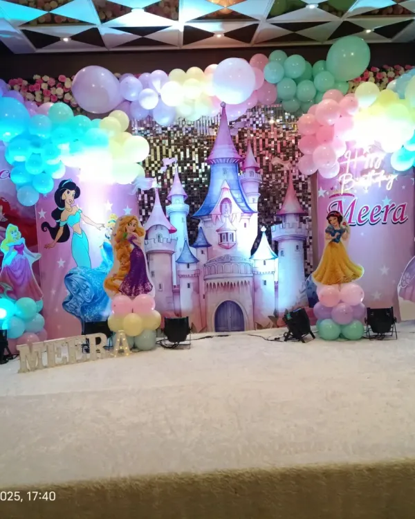 A magical princess party with a castle backdrop and cutouts of famous princesses like Rapunzel, Belle, and Jasmine. The pastel balloon decor adds to the enchanting atmosphere.