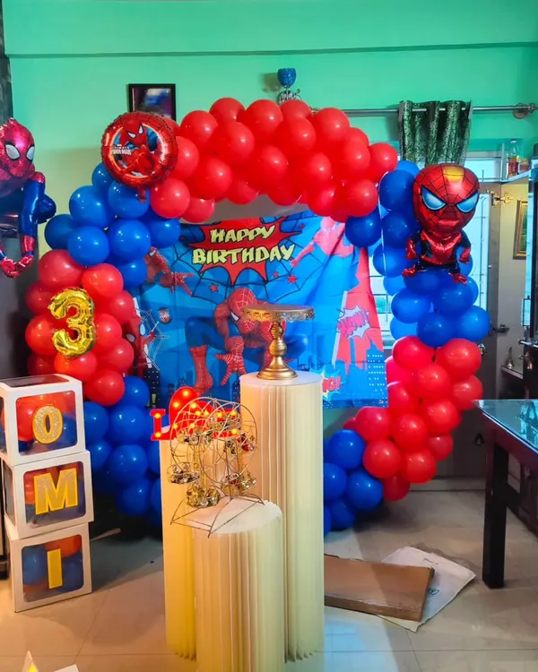 I can bring any superhero theme to life for your child's party. This Spiderman setup includes a classic red and blue balloon arch, a city-scape backdrop, and a large inflatable Spiderman figure to complete the action-packed look.