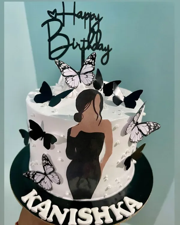 This cake combines two popular trends: a minimalist silhouette and delicate butterflies. The elegant black dress illustration paired with black and white butterflies creates a modern and fashionable birthday cake.