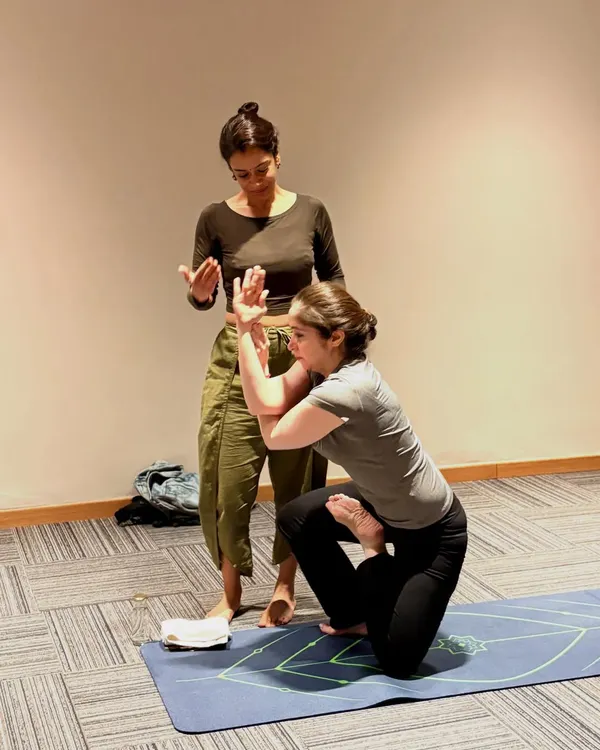 I love each of my students. When I teach, I give every ounce of my energy to their growth. Here, I am assisting a student in Vatayanasana, helping her find the correct alignment in the arms.