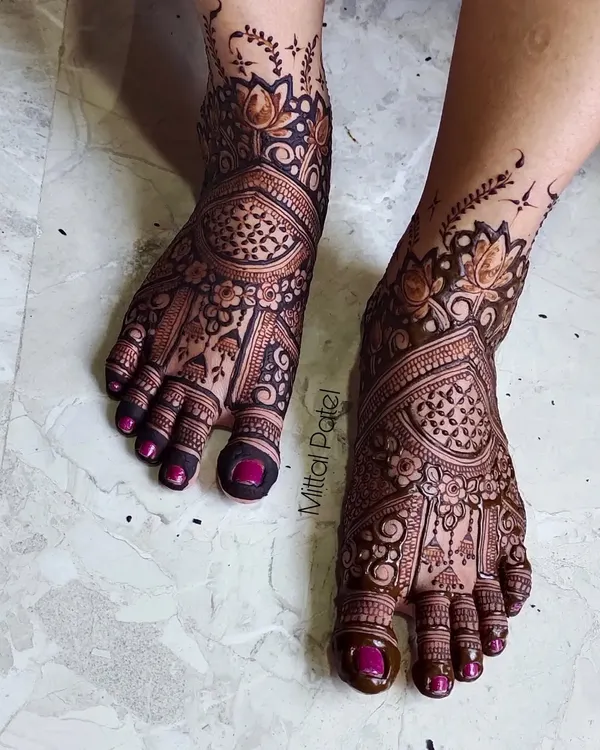 A stunning example of full-coverage bridal foot mehndi. The design is intricate and dense, featuring beautiful floral and paisley patterns that extend from the toes to the ankles.