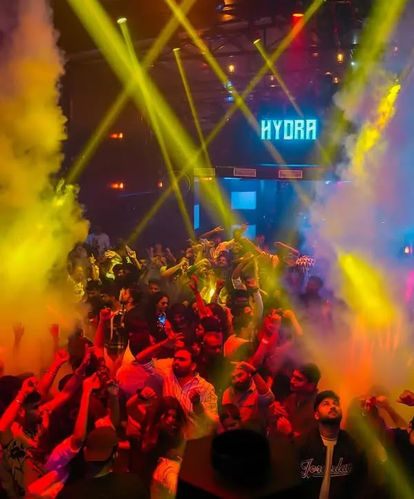 An aerial view of the packed dance floor at Hydra, lit up by yellow laser beams and smoke effects. This is the peak-hour energy I build with my commercial and techno sets.