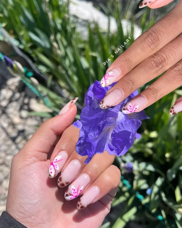 This cute set was inspired by a photo the client brought in. It features a delicate French tip with a mix of pink floral and leopard print hand-painted art.