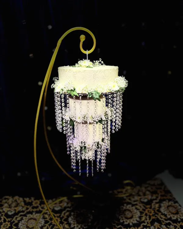 My signature chandelier wedding cake. This design hangs elegantly from a custom stand, adorned with cascading crystals and fresh flowers, creating a breathtaking centerpiece that appears to float in mid-air.