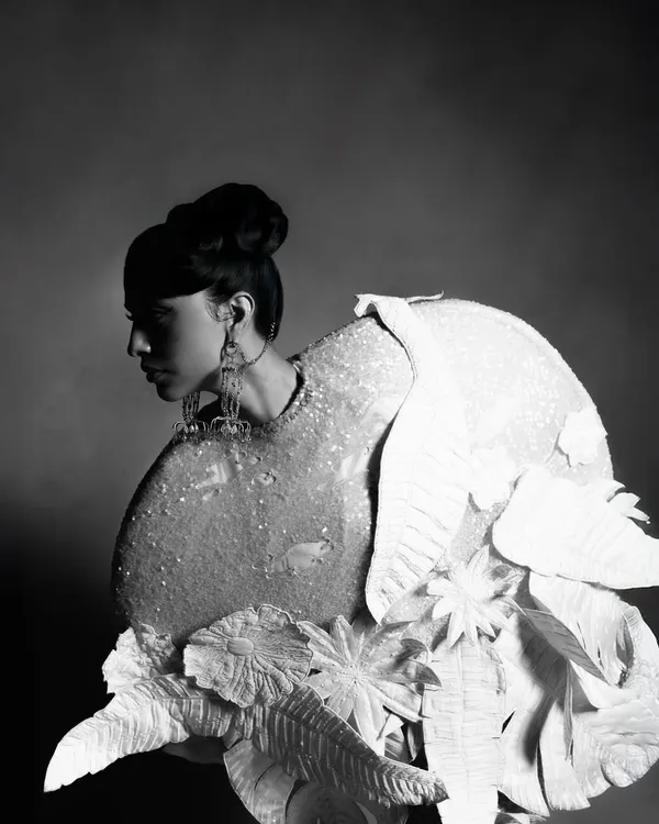 A black and white profile portrait for designer Rahul Mishra's collection, featured in Hindustan Times. This shot focuses on the sculptural quality of the garment and the model's strong silhouette, creating a dramatic, high-fashion editorial image.
