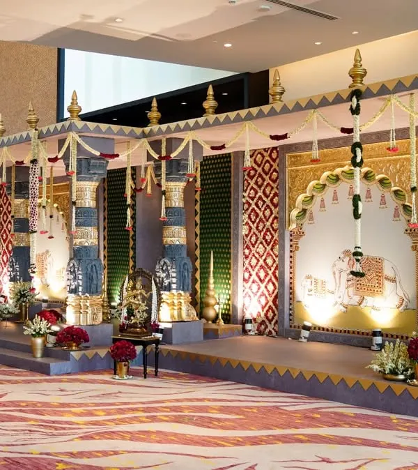 The grand entrance to our temple wedding concept. We designed this passage with towering Tanjore paintings, intricate floral work, and cascading garlands to transport guests into a world of divinity and artistry before they even entered the main hall.