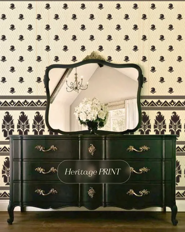 This heritage print wallpaper combines a small, delicate buti pattern with a bold, contrasting border. Paired with ornate, dark furniture, it creates a look that is both classic and dramatic.