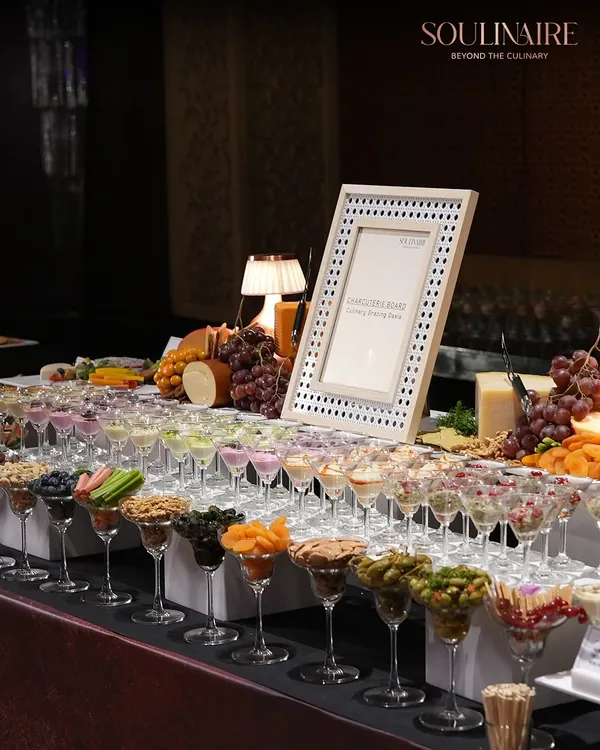 A magnificent charcuterie and cheese board, artfully arranged in martini glasses and on platters. This is a perfect example of how we turn simple grazing into an exquisite experience.