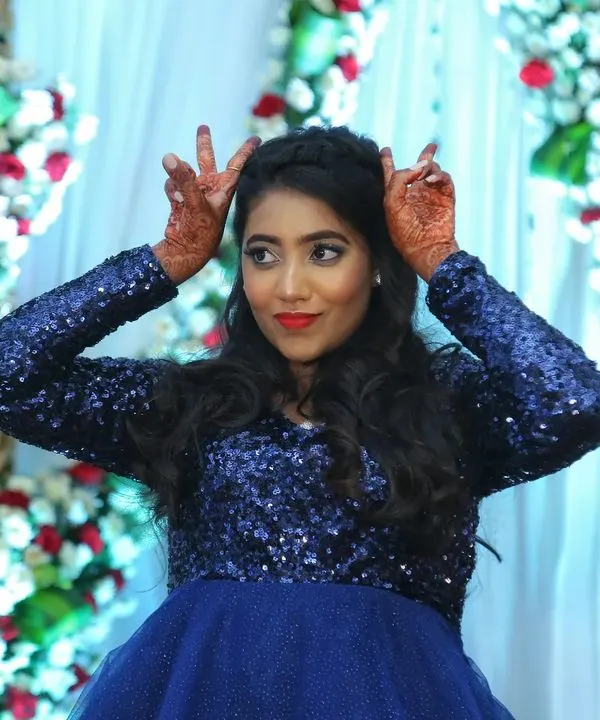 This bride is having the best time at her reception. Her fun personality shines through, and the glam makeup with a bold red lip and sparkling eyes is designed to last through a night of dancing.