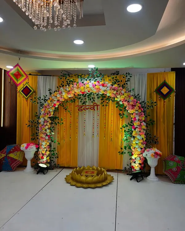 This vibrant Haldi ceremony stage is one of my most requested designs. The bright yellow drapes, a full arch of fresh marigolds and colorful flowers, and the traditional 'urli' seating create a picture-perfect and festive atmosphere for your pre-wedding celebrations.