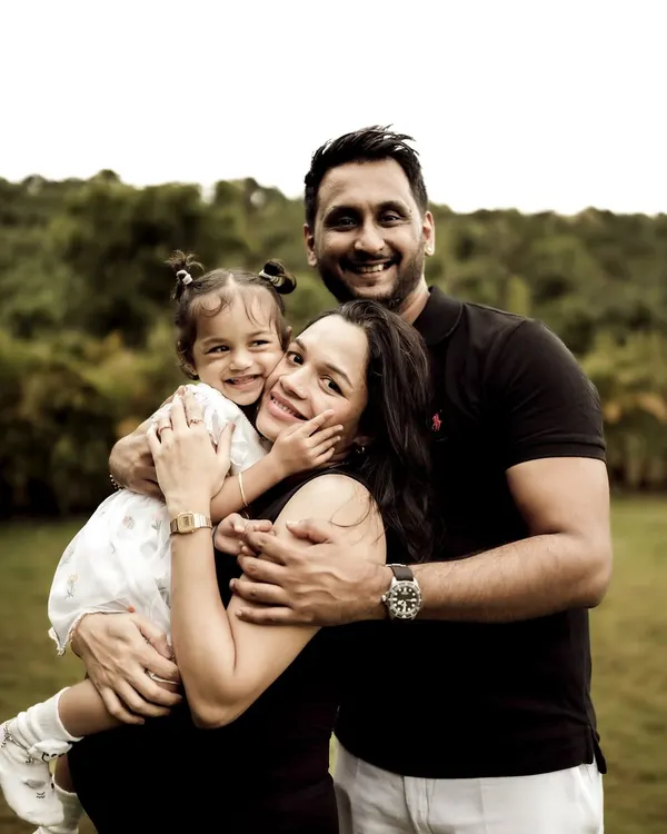 The perfect family hug. This portrait captures the joy and love of a family of three, soon to be four. The daughter's happy face nestled between her parents is a priceless memory.