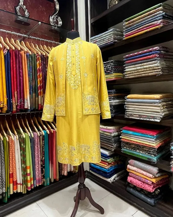 A custom-tailored menswear set in our store. This yellow silk kurta with a matching embroidered jacket is an example of the festive attire we create for our clients.