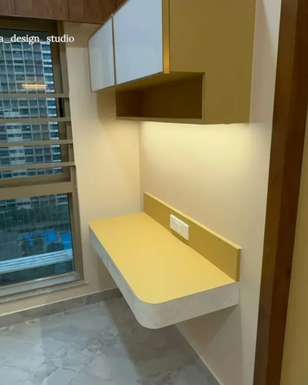 This bright and modern study nook features a floating desk in a bold mustard yellow, providing a vibrant pop of color. The simple overhead cabinets and warm under-shelf lighting create an inspiring and clutter-free zone for homework.