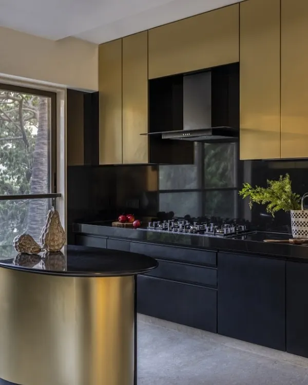 Behold, the Black & Gold Marvel. In this 2600 sq. ft. Mumbai duplex, I designed this kitchen to be an opulent oasis. The striking blend of sleek black finishes and lavish gold accents, crowned by a mesmerizing curved island, redefines luxury living.