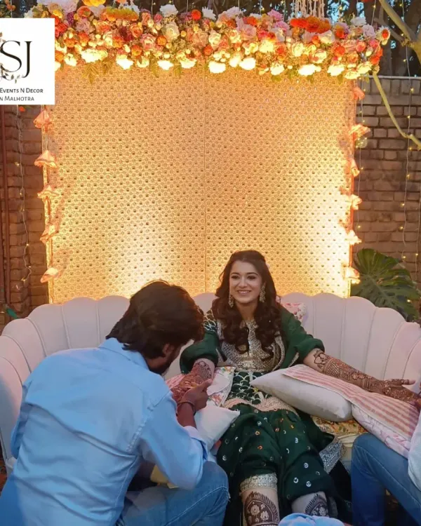 A beautiful Mehandi ceremony where the bride is the center of attention. I designed a lovely backdrop with a floral canopy and soft lighting to create a perfect setting for her.