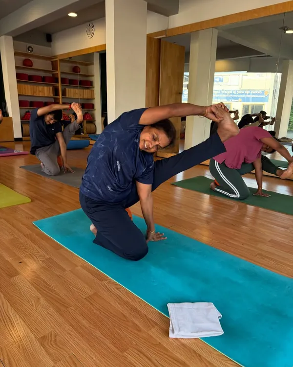 A student joyfully practices a seated twist, embodying the balance and strength we cultivate in our classes.