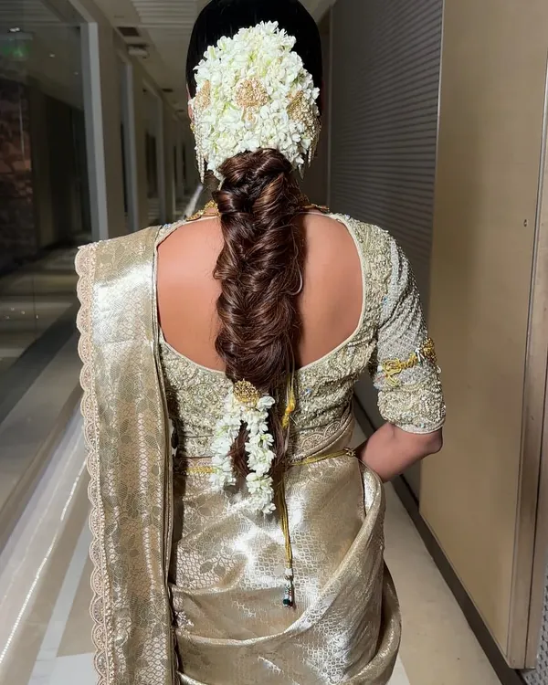 This is my take on the classic South Indian bridal braid, also known as Poola Jada. I've used a thick, fishtail plait as the base and adorned it with fragrant jasmine (mogra) gajra and traditional gold ornaments for a truly regal wedding day look.