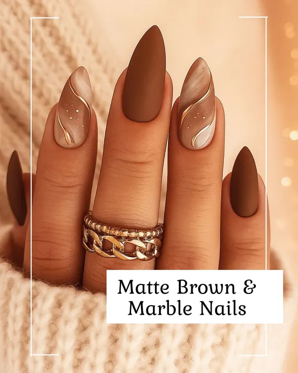 A sophisticated look featuring almond-shaped nails with a combination of solid matte brown and delicate marble art. The accent nails include soft white and brown swirls, highlighted with a fine gold line for a touch of luxury.
