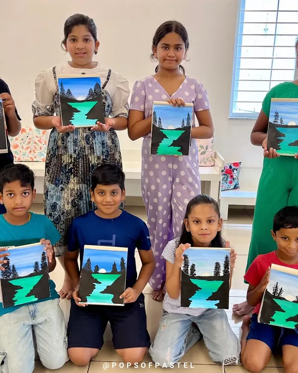 A group of proud young artists showing off the landscape paintings they completed during our 10-day acrylic painting course.