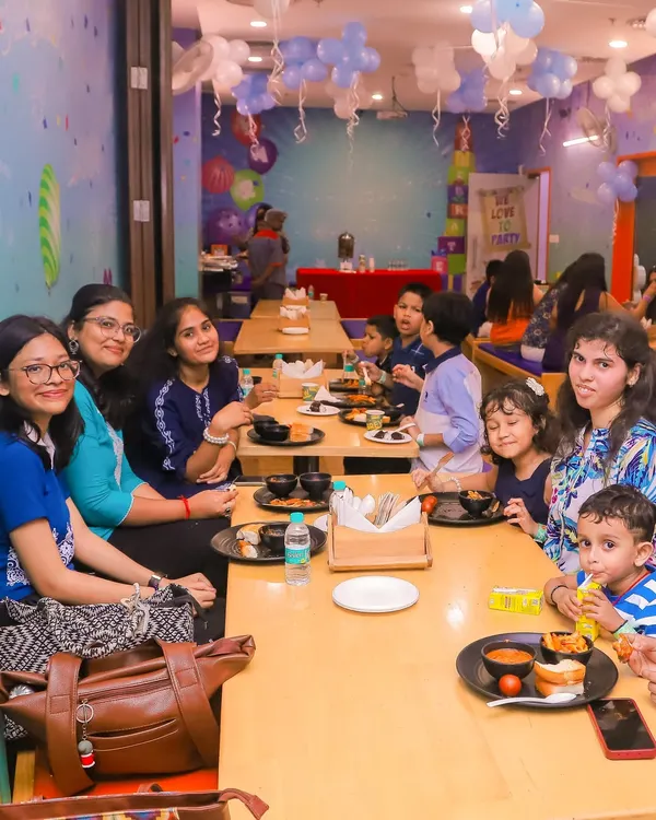 Families enjoying a meal together in our spacious cafe area. The cafe is conveniently located right next to the play zones.