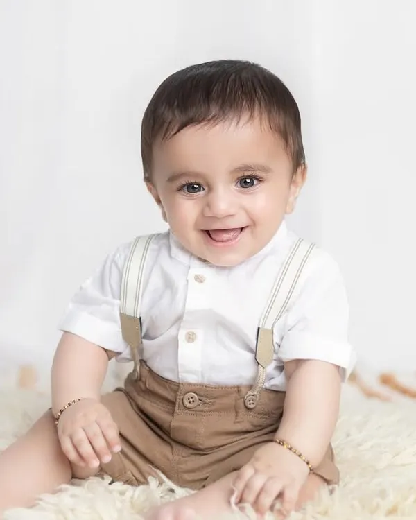 What a happy smile! Sitter sessions around 7-9 months are perfect for capturing your baby's joyful personality as they learn to sit up on their own.
