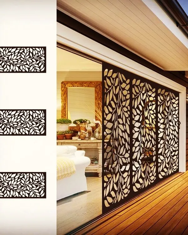 This laser-cut metal screen is a beautiful and functional solution for privacy. It separates the outdoor and indoor areas while allowing light to pass through, casting intricate, leaf-patterned shadows.