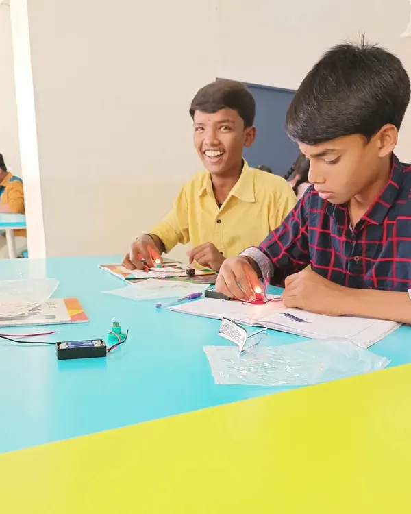 The smile of success! This student just completed his first circuit, and the bulb lit up. It's these moments of achievement that build confidence and a love for science.