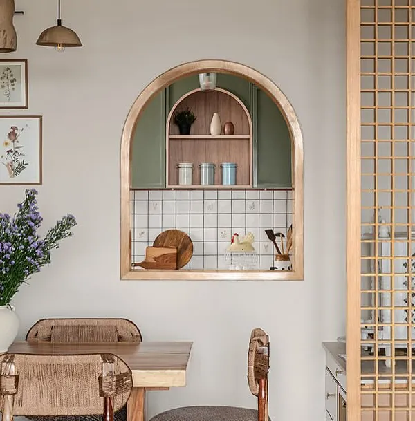 A small arched opening between the dining room and kitchen creates a beautiful connection between the two spaces. It frames the view into the kitchen like a piece of art and allows light and conversation to flow freely.