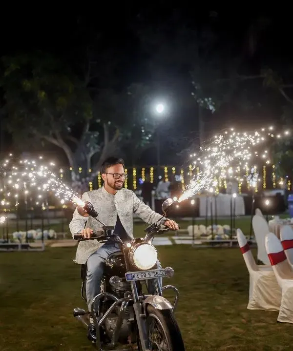 The groom makes his solo entry on a classic Royal Enfield, complete with handlebar-mounted sparklers. This is a total hero moment that gets the crowd hyped up for the night.