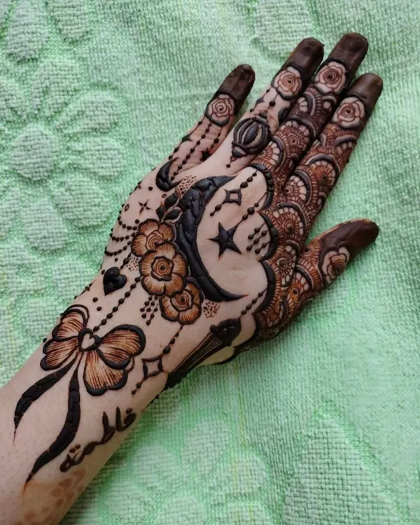 A whimsical and charming design perfect for a party or special event. It features a crescent moon, stars, a bow, and delicate floral elements, with a name personalized on the wrist.