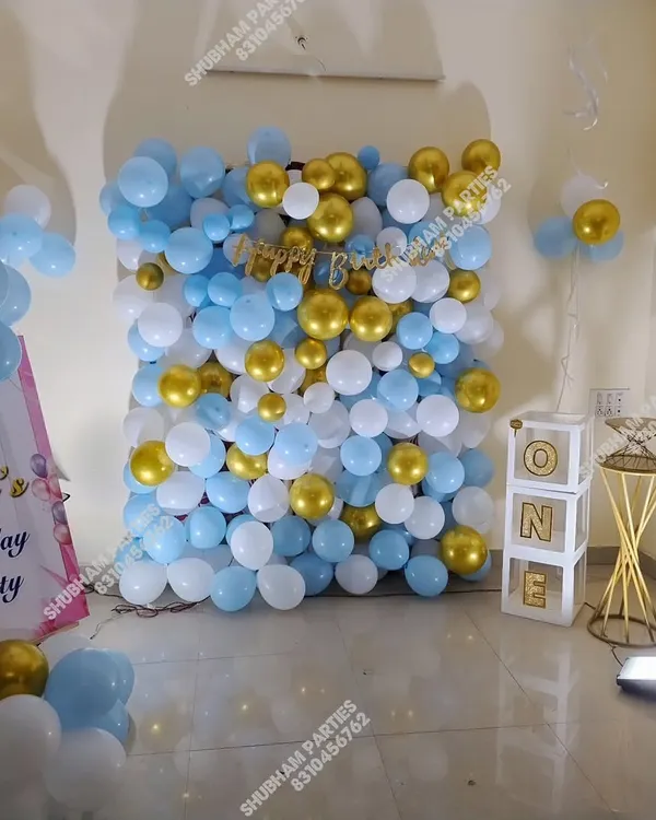 A full balloon wall in light blue, white, and gold, creating a fantastic photo backdrop.