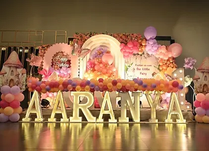 This is what we mean by a fairytale first birthday. For Aaranya's celebration, we created a breathtaking butterfly and fairy theme, complete with large marquee letters spelling out her name, a multi-layered balloon arch in sunset colors, and custom mushroom house props to complete the enchanted forest look.