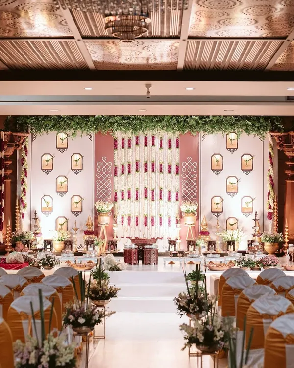 A grand yet intimate engagement stage setup. We used traditional elements like floral tuberose strings and parrot motifs in wall niches to create a backdrop that is rich in South Indian culture and symbolism.