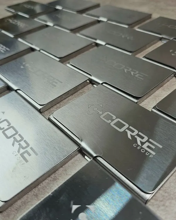 A bulk order of sleek, brushed metal card holders, each engraved with the "Corre Group" logo. These make for a professional and practical corporate gift.