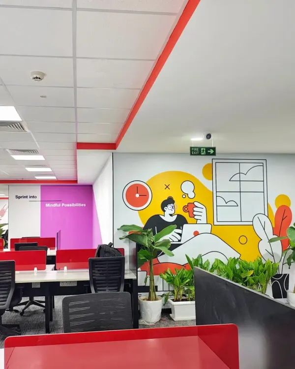 A view across the Mindsprint office, where we integrated playful wall murals and potted plants among the workstations. This approach adds personality and a touch of nature to the open-plan layout, making the space more engaging for employees.