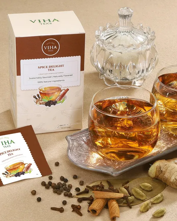 A warm, inviting lifestyle scene for a spice delight tea, showcasing the packaging alongside a prepared cup and the raw spices used in the blend.