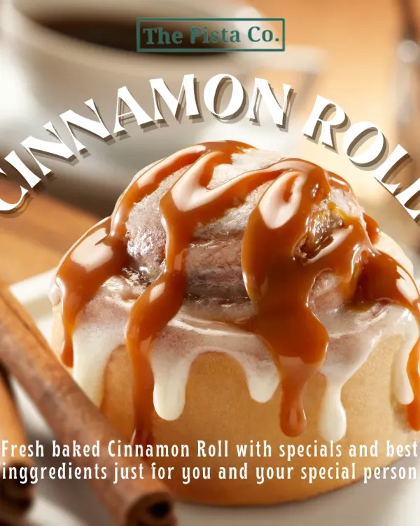 A close-up of our signature Cinnamon Roll, fresh from the oven. Notice the generous drizzle of rich caramel sauce and sweet cream cheese frosting over the soft, spiraled dough, with cinnamon sticks in the background hinting at the warm spices within.