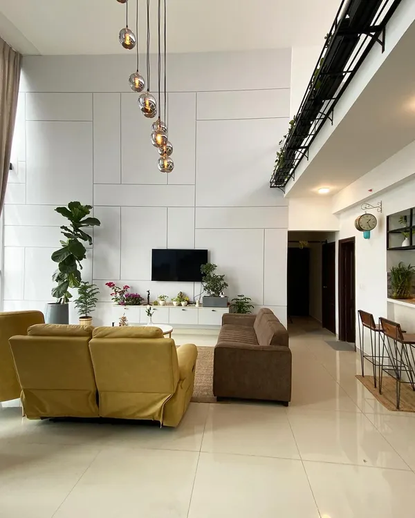 This penthouse living room is the definition of minimalist luxury. I used a clean white palette, comfortable sofas, and a stunning cascading chandelier to make the double-height space feel grand yet inviting.
