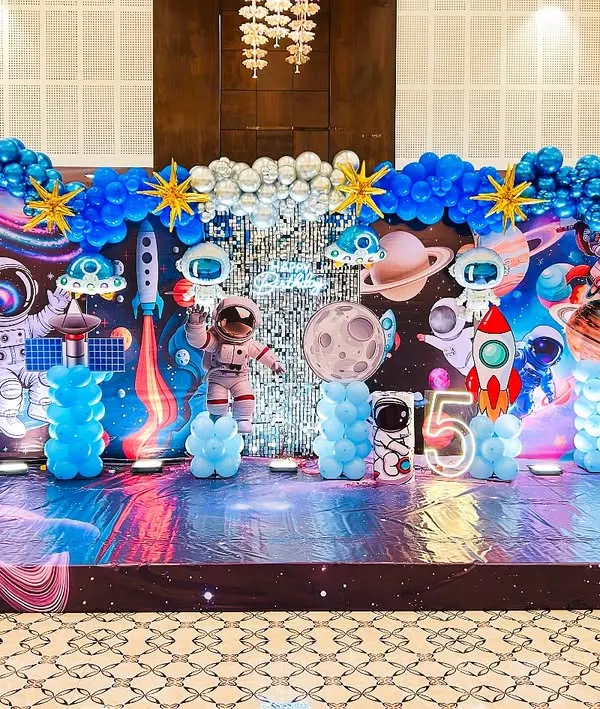 I transformed this hall into an entire galaxy for a 5th birthday. This space adventure theme features a custom-printed backdrop with planets and stars, astronaut cutouts, rocket ships, and even themed flooring to complete the immersive experience.
