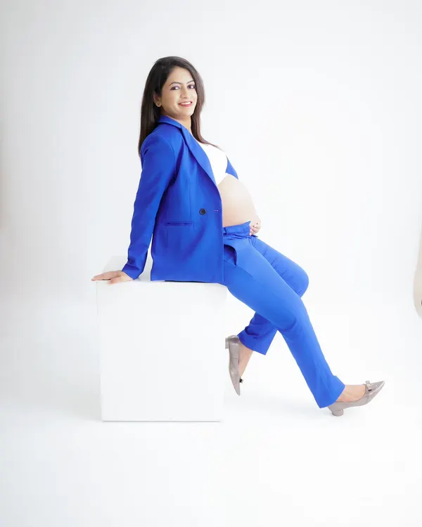 A powerful and chic "boss mama" look. This portrait features a stylish royal blue suit, showing that pregnancy is a time of strength and confidence.