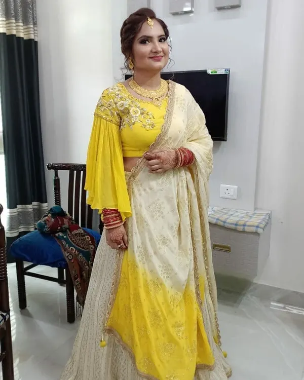 This client was getting ready to celebrate her first wedding anniversary. Here is her full look, featuring a beautiful yellow and white lehenga, traditional red bangles, and makeup designed to last through the celebration.